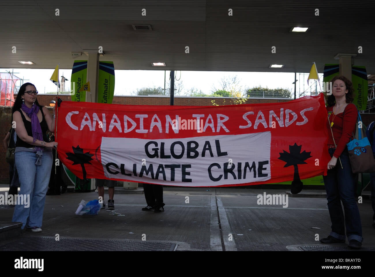 Aktivist halten einen Tar Sands "Globale Klima Verbrechen" Banner auf dem Vorplatz der BP-Tankstelle. Stockfoto