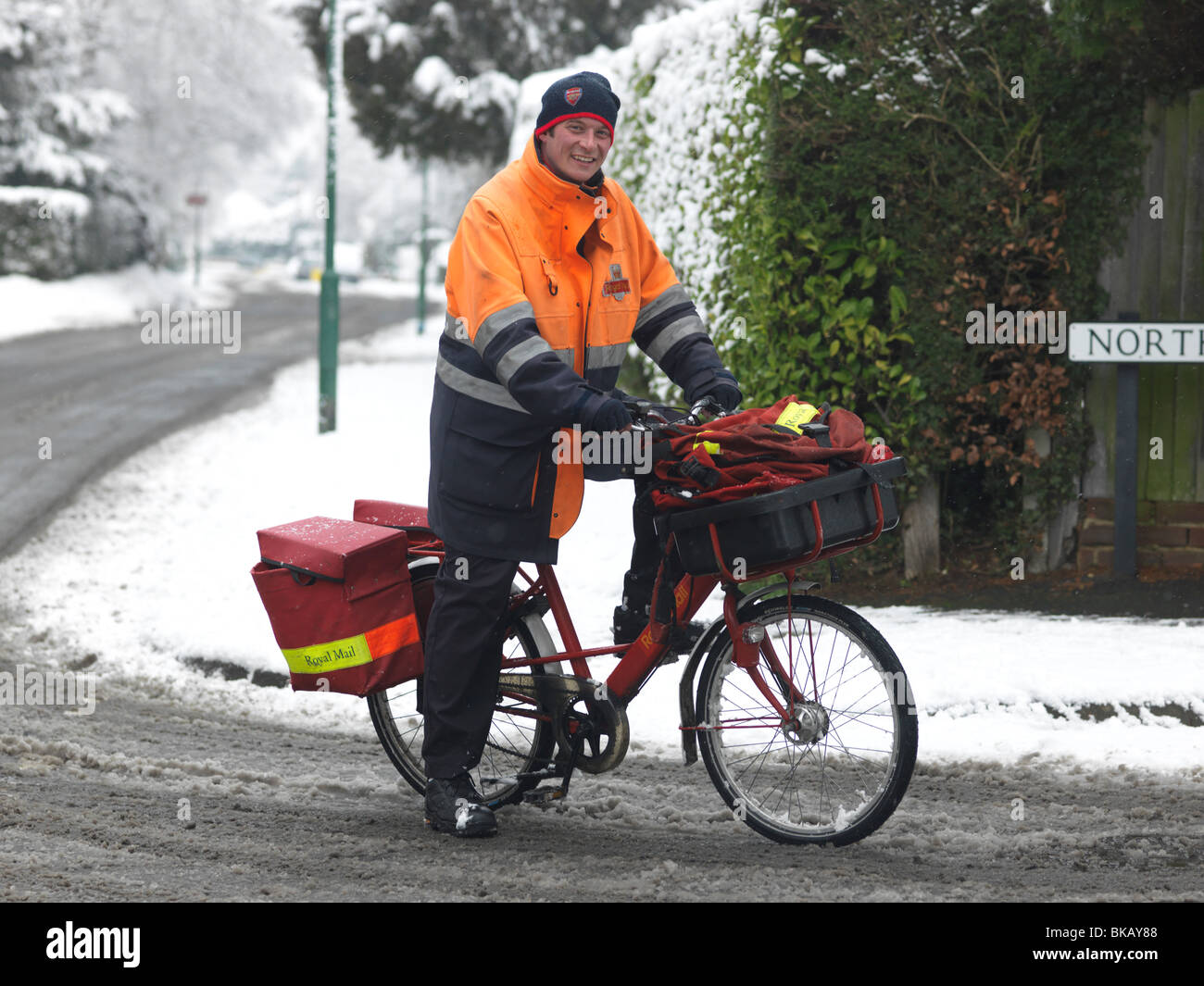 Postbote auf Fahrrad In die Snow Surrey England Stockfoto