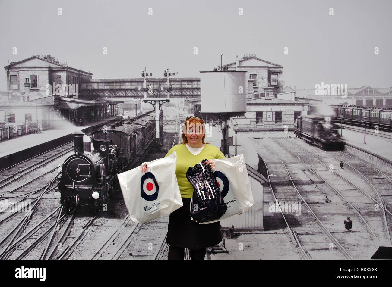 Frau mit Einkaufstüten vom alten Bahnhof drucken, Swindon Designer Outlet, Swindon, Wiltshire, England, Vereinigtes Königreich Stockfoto