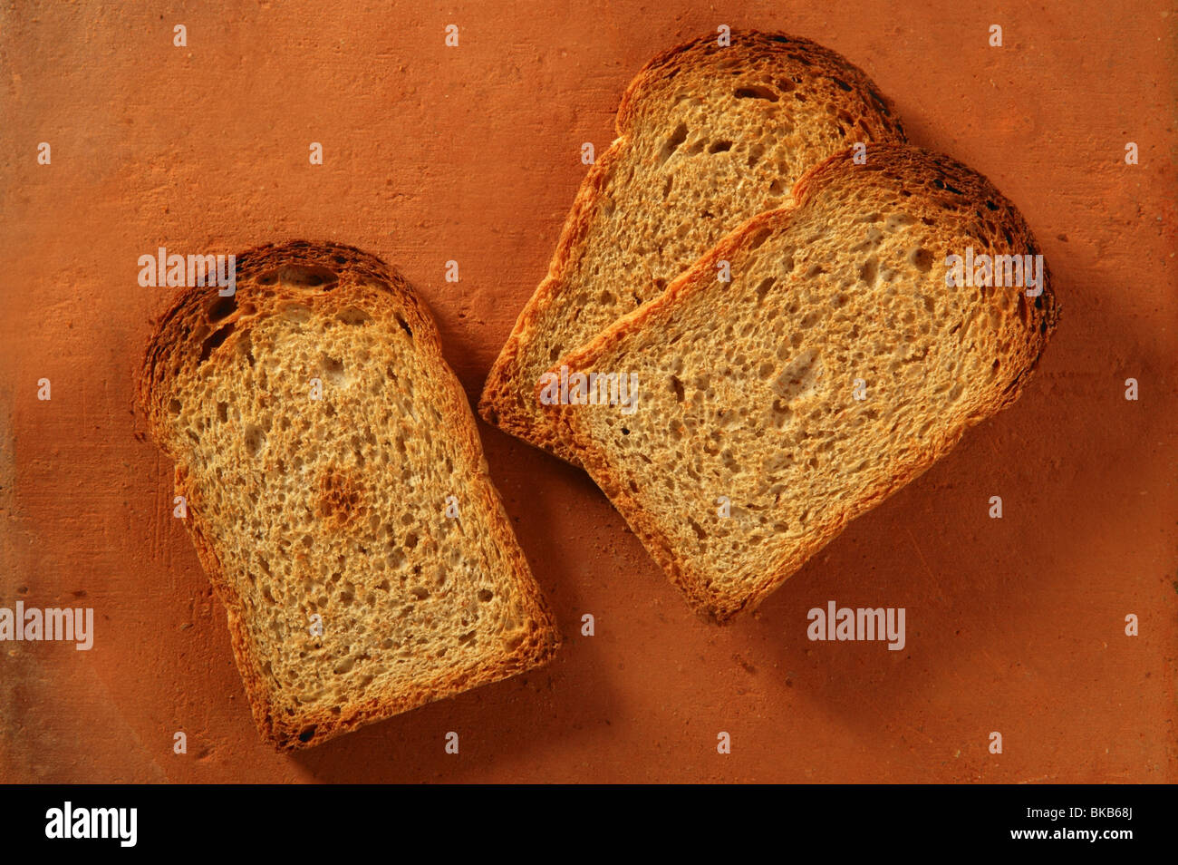 Geröstete Brotscheiben über orange Ton Hintergrund Stockfoto