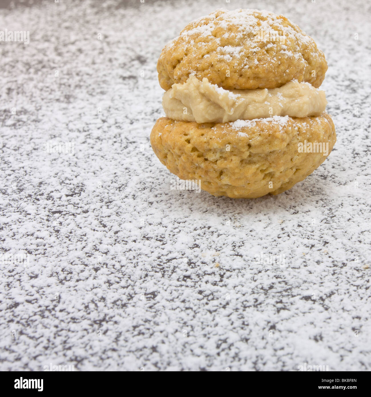 Kaffee küssen Kekse mit Prise Puderzucker und Butter Creme-Füllung. Stockfoto