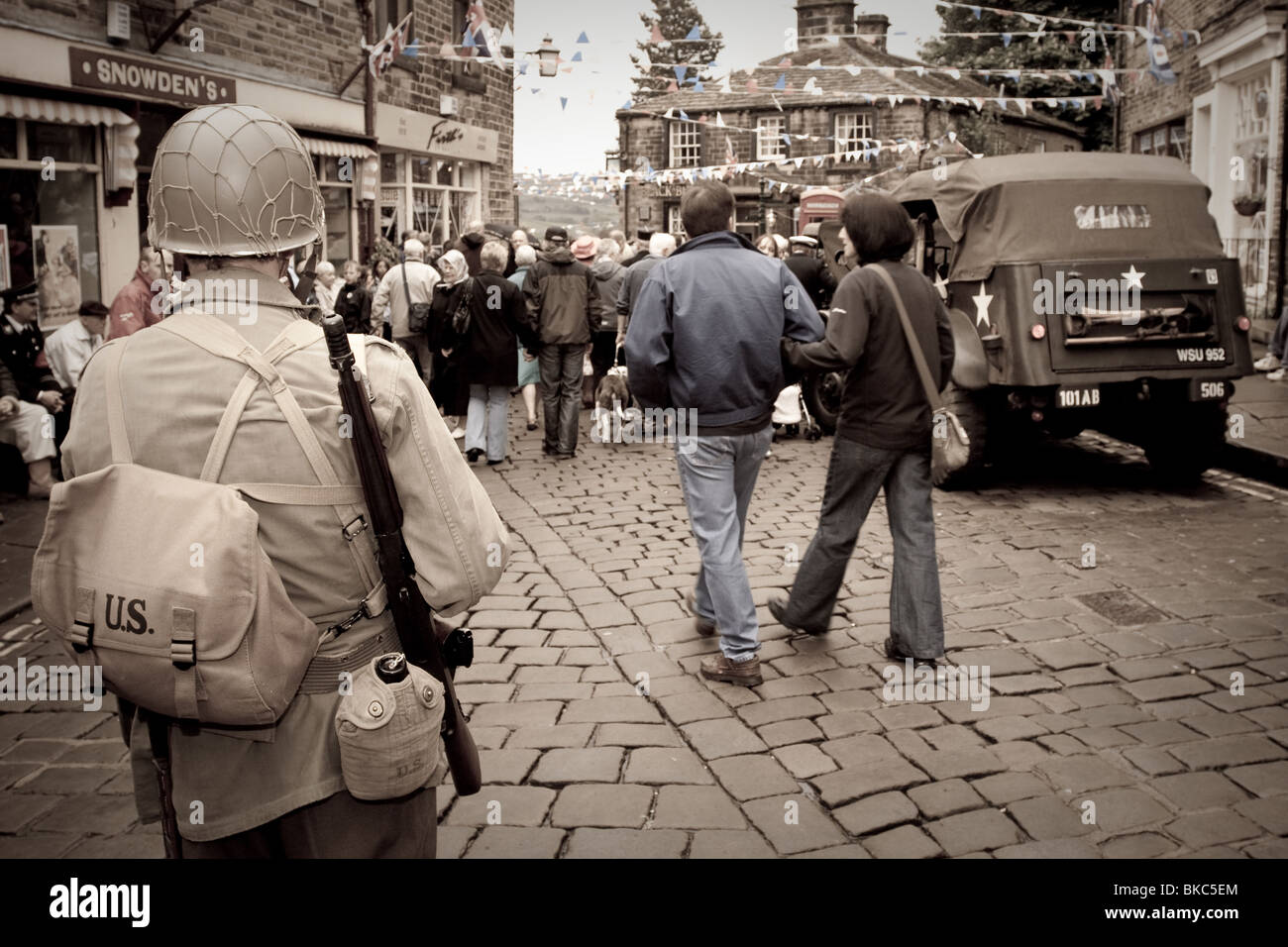 Ein Mann als US-Soldat verkleidet steht auf einer gepflasterten Straße während einer Veranstaltung der 1940er Jahre in Haworth, Vereinigtes Königreich Stockfoto