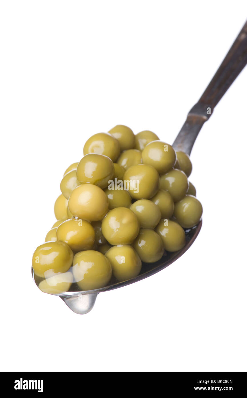 Objekt auf weiß - Essen grüne Erbsen auf Löffel Stockfoto