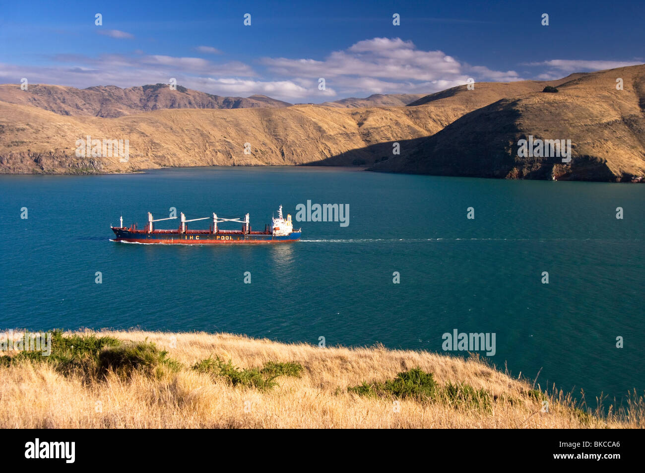 Ein Frachtschiff nach außen gebunden von Lyttelton, Neuseeland an einem sonnigen Tag. Stockfoto