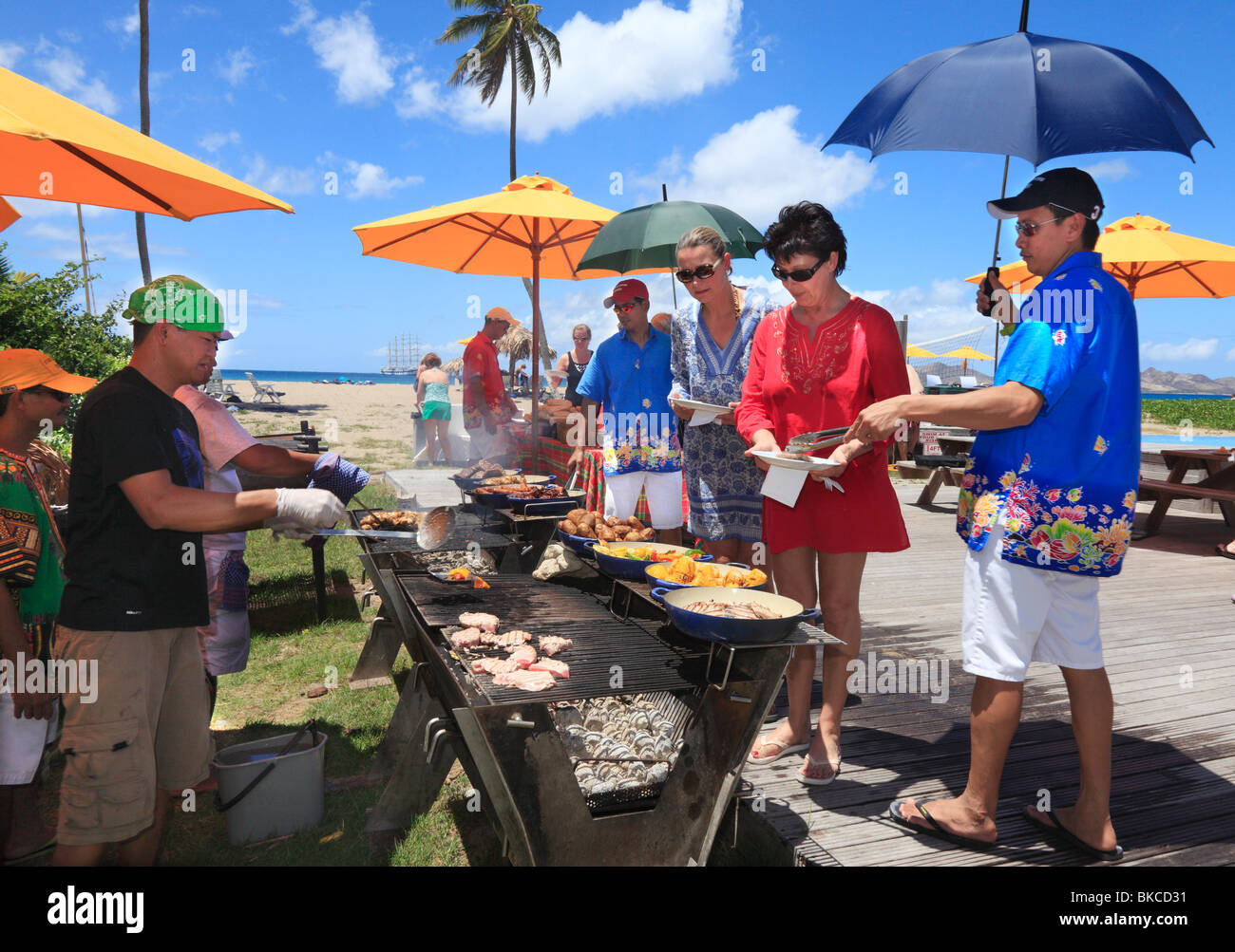Barbecue am Strand von Nevis, für die Passagiere auf dem Kreuzfahrtschiff vor Anker in der Ferne. Stockfoto