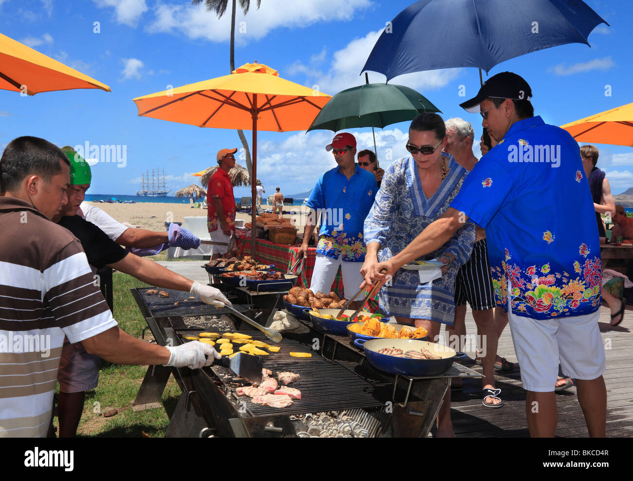 Barbecue am Strand von Nevis, für die Passagiere auf dem Kreuzfahrtschiff vor Anker in der Ferne. Stockfoto