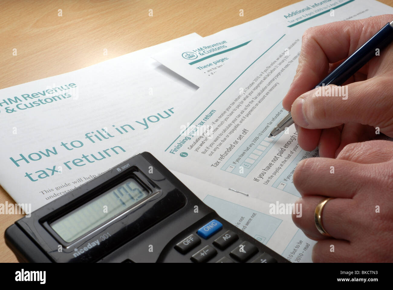 Starten Sie den schmerzhaften Prozess der Ausfüllen einer Steuererklärung.  Mit Stift und Taschenrechner, um zusätzliche Informationen eingeben Stockfoto