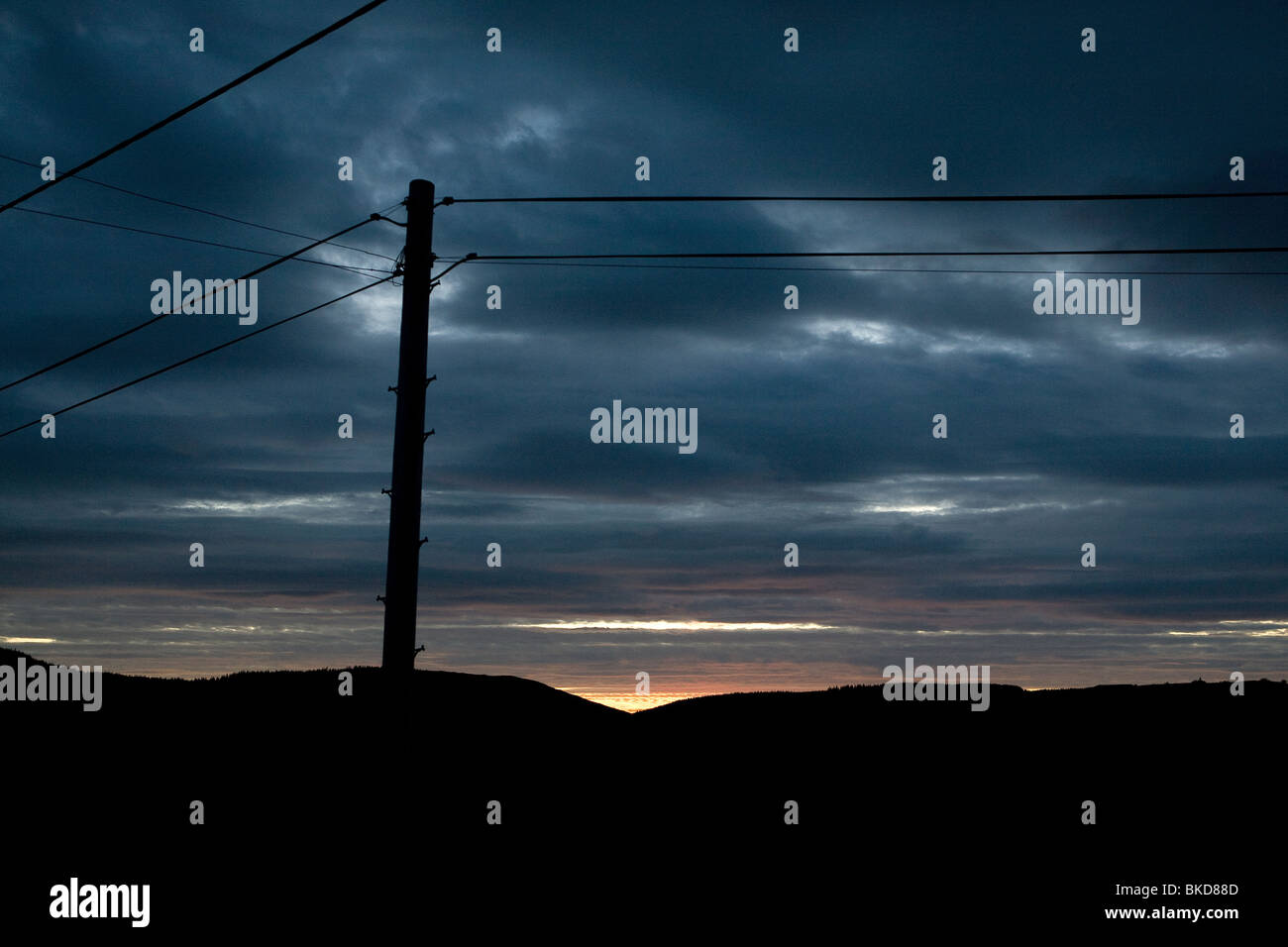 Sonnenuntergang und Silhouette macht Powerlines in Wales. Stockfoto