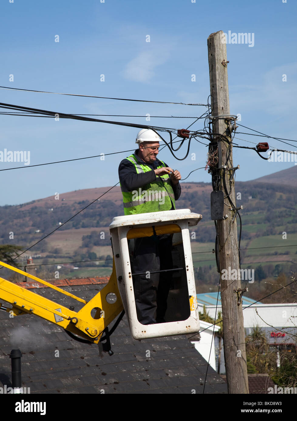 British Telecom Ingenieur in Hebezeug Reparatur Telefonleitungen auf Telegrafenmast Wales UK Stockfoto