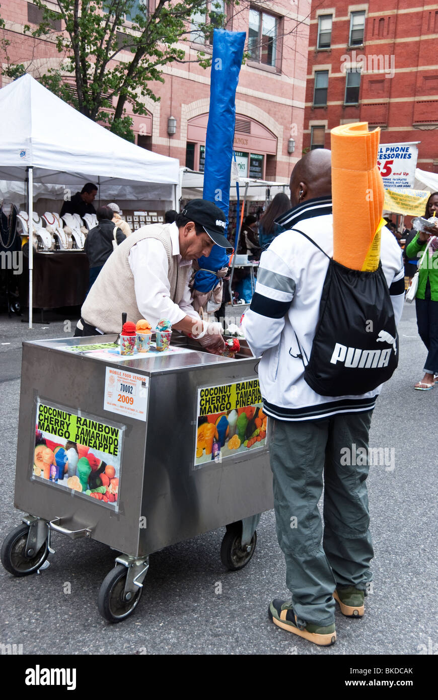 schwarzer Mann Kauf rasiert italienisches Eis von mobilen Anbieter Ninth Avenue New York 9. Ninth Avenue International Food Festival Stockfoto