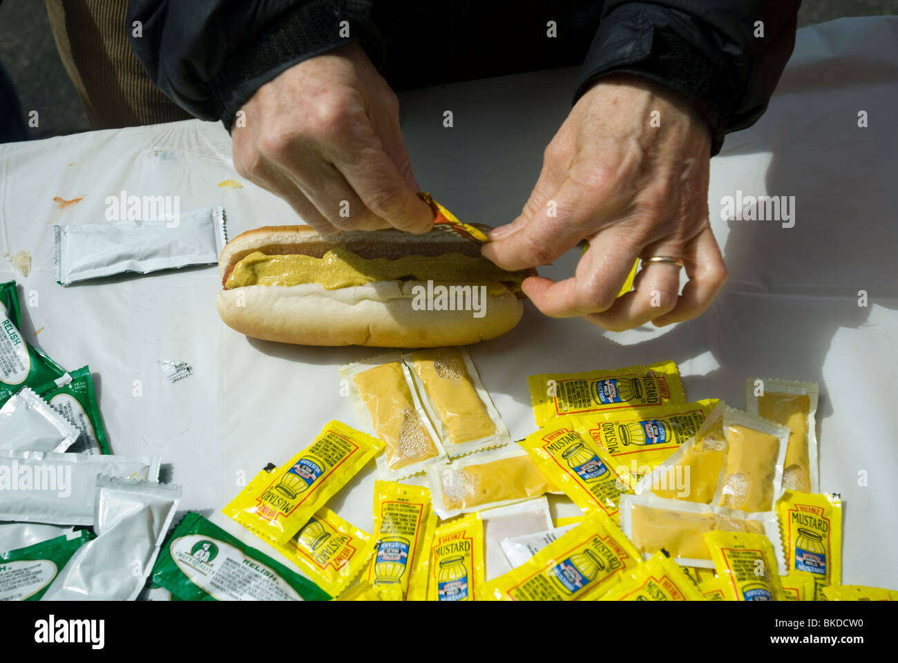 Ein hungriger Festival Teilnehmer setzt Senf auf einen Hot Dog in New York auf Sonntag, 18. April 2010. (© Richard B. Levine) Stockfoto