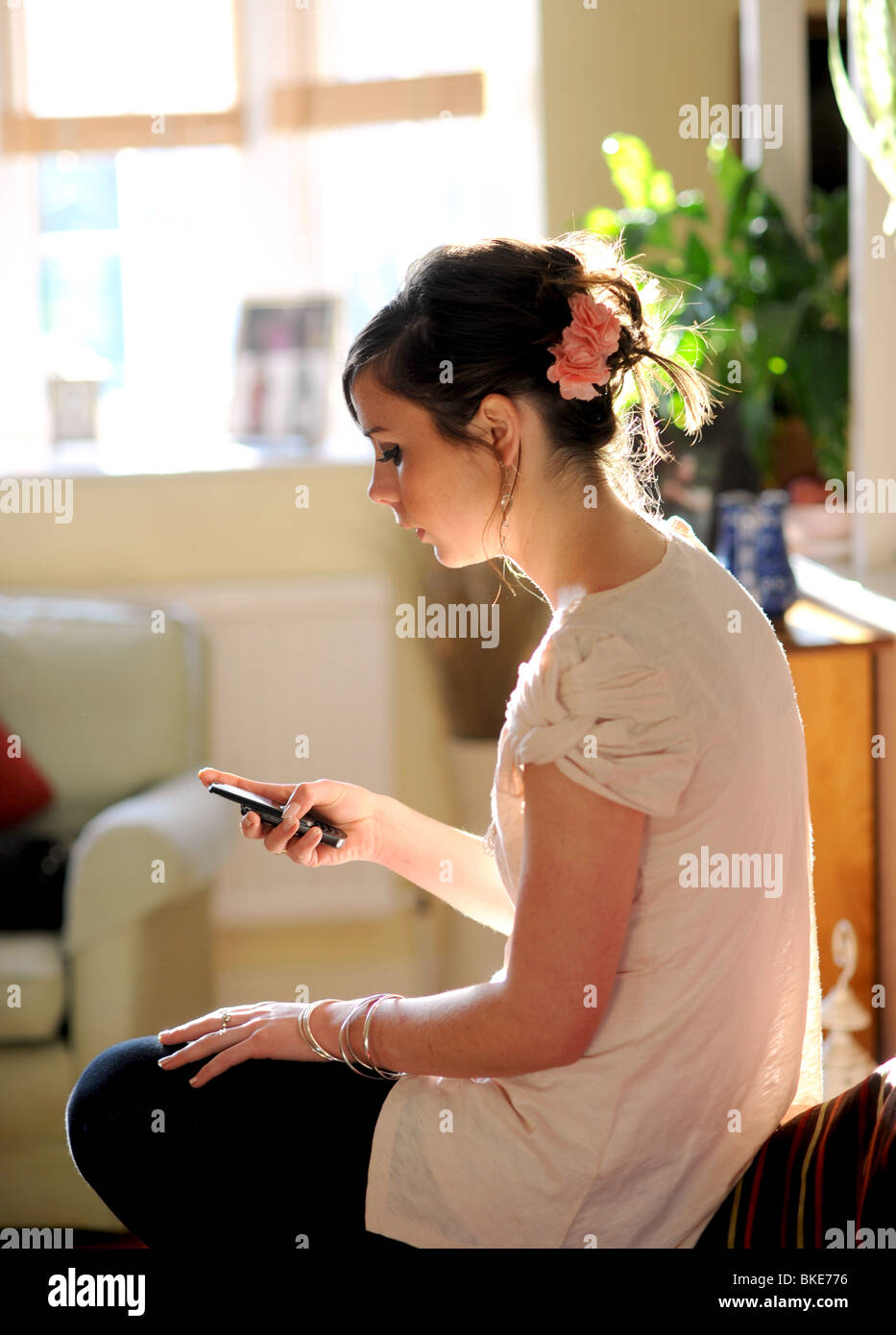 Junge Frau weiblich in zwanziger Jahre mit ihrem Handy einen Meldungstext senden der 20er Jahre Stockfoto