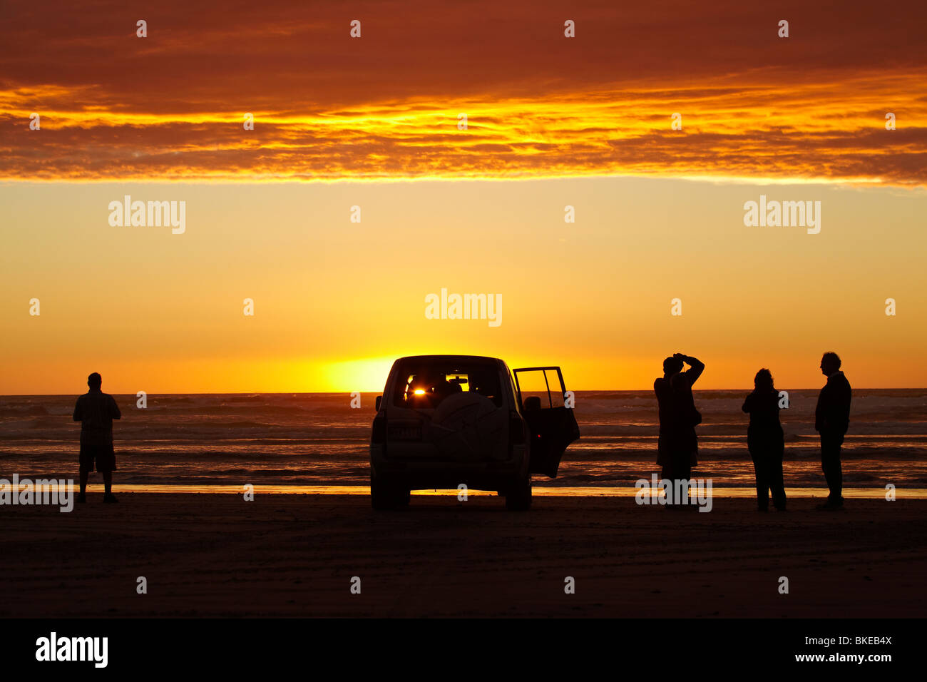 Sonnenuntergang über Southern Ocean, Four Wheel Drive und Menschen, Ocean Beach, in der Nähe von Strahan, westlichen Tasmanien, Australien Stockfoto
