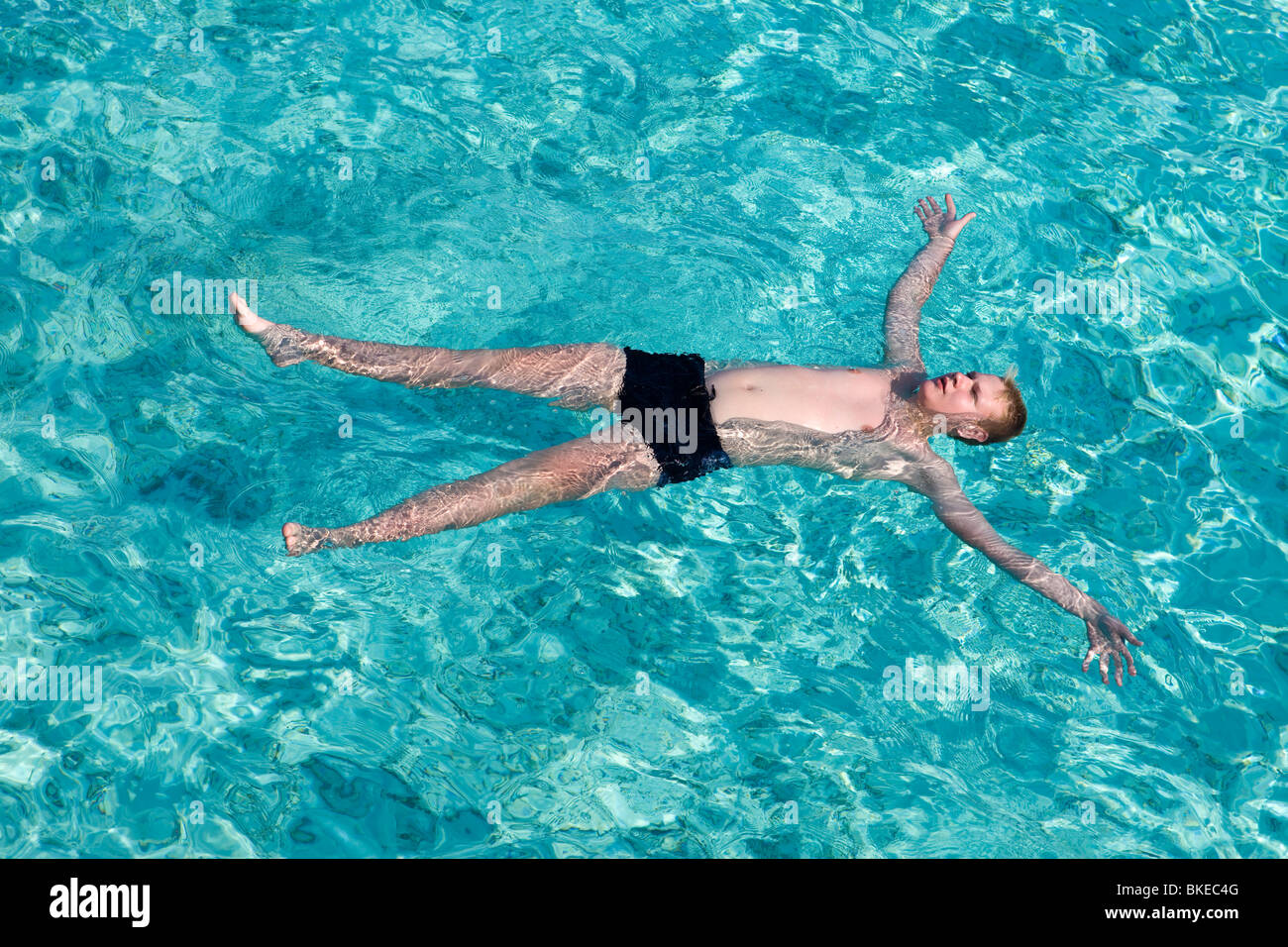 Malediven. Teenager hat einen Rest auf türkisfarbenem kristallklarem Wasser des Ozeans Stockfoto
