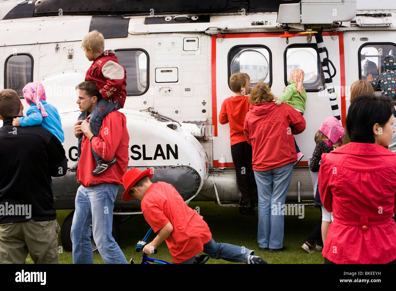 Menschen versammeln sich um einen Hubschrauber von der isländischen Küstenwache, Vogar in Vatnsleysustrond, Island. Stockfoto