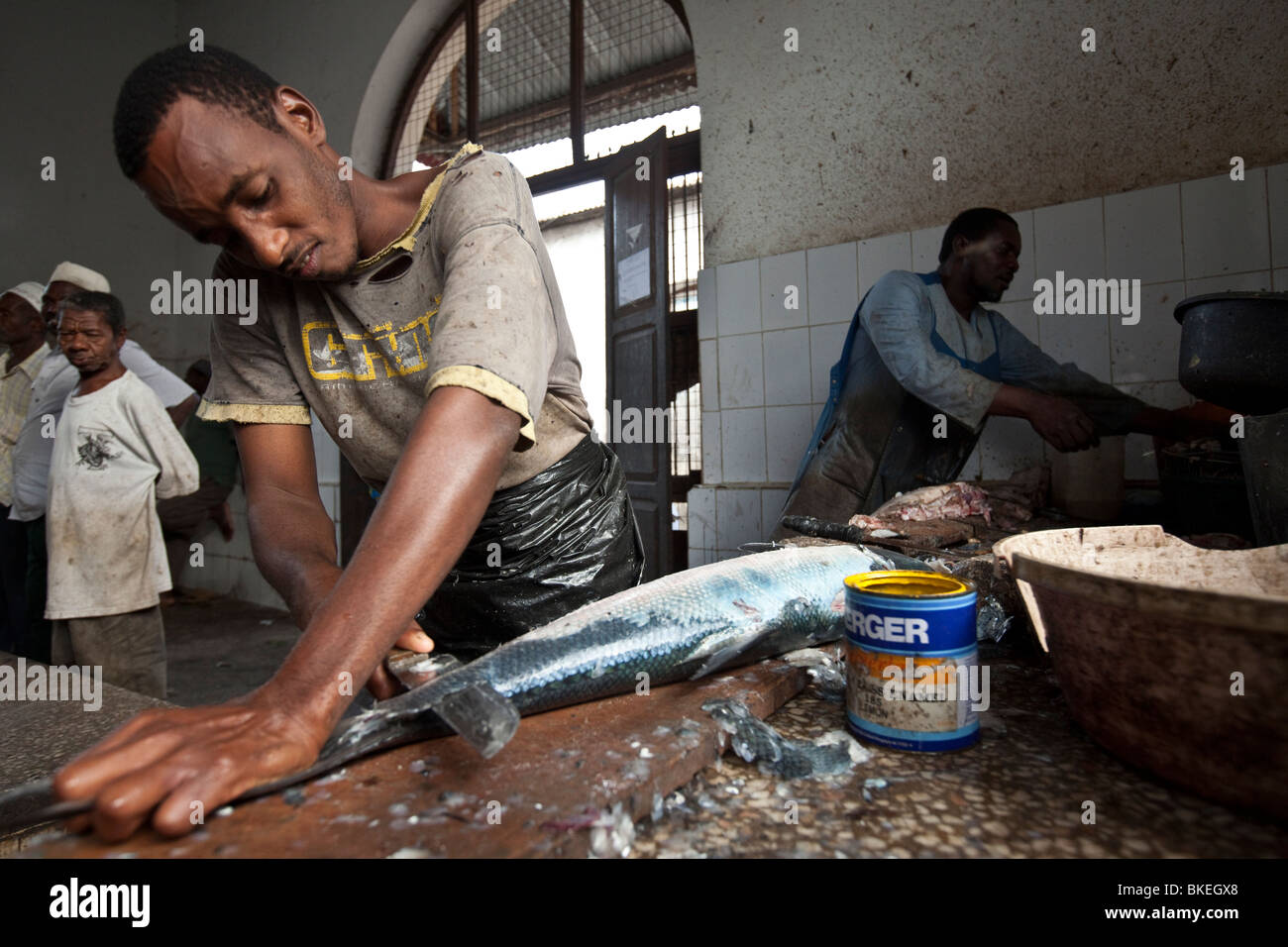 Mann Reinigung Fisch - Stonetown, Sansibar, Tansania. Stockfoto