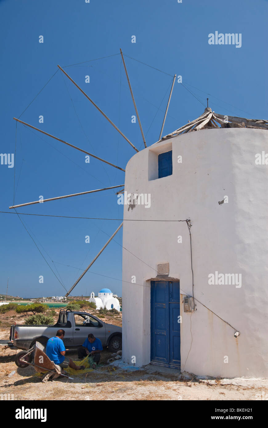 Eine griechische Insel-Szene der Fischer Flicken ihre Netze neben einer Windmühle auf Antiparos Insel, Griechenland Stockfoto