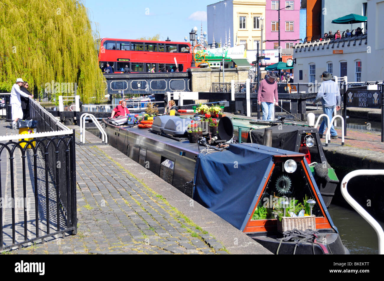 Schleusentore sonnige Stadtlandschaft & Narrowboot Szene Camden Lock Regents Kanal mit Doppeldecker roten öffentlichen Verkehrsmitteln Bus an Bridge London England Großbritannien Stockfoto