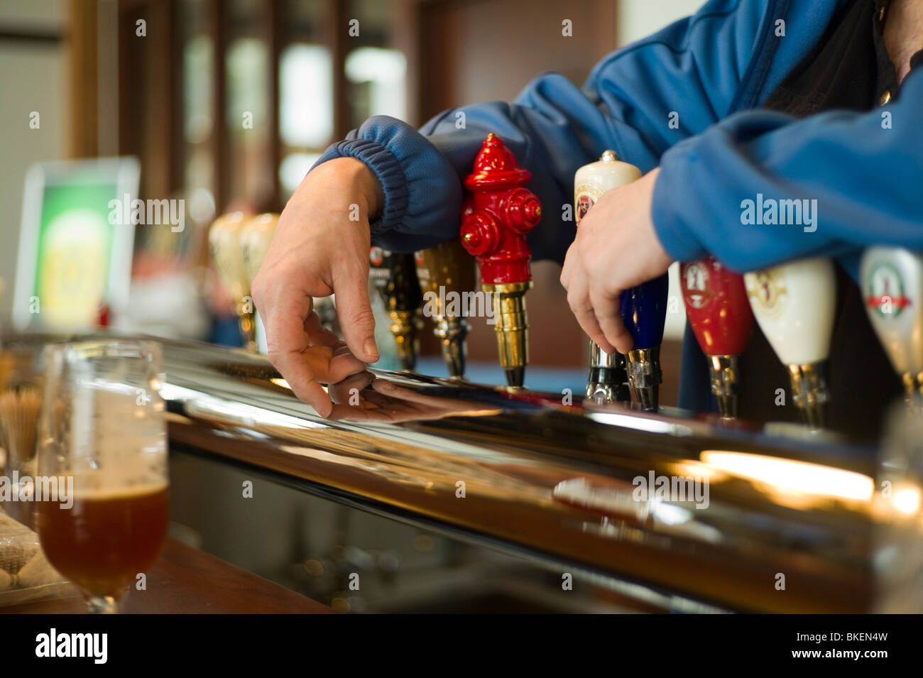 Bartenders Hände ruhen auf Bier-Armaturen. Stockfoto