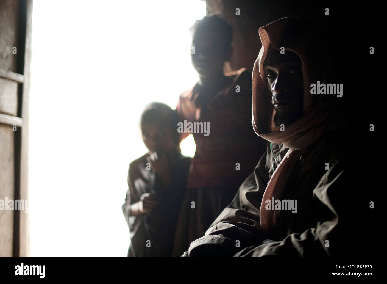 Ein Mann und zwei Kindern in dunklen Innenraum einer äthiopischen Hütte Stockfoto
