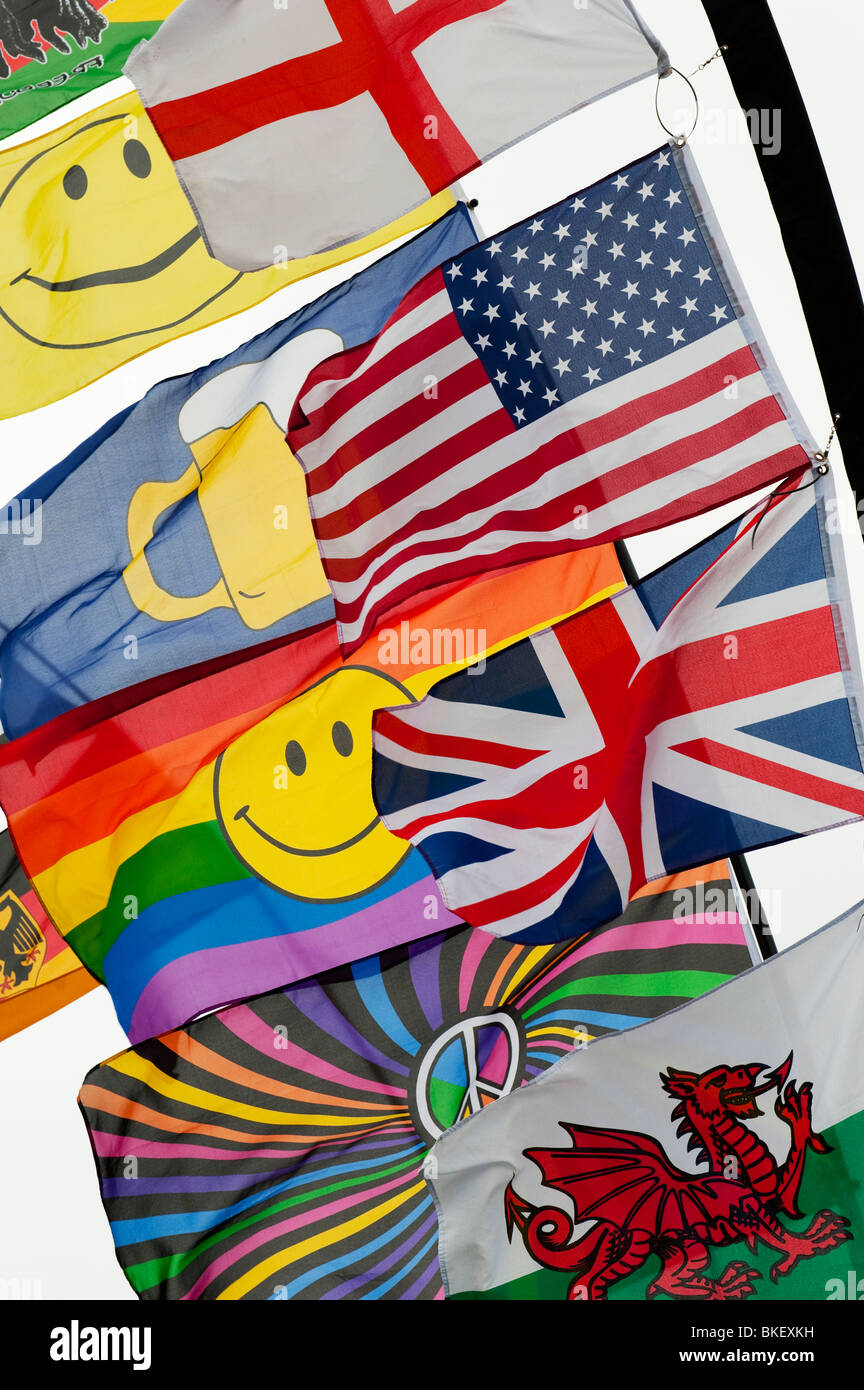 Leuchtend bunte Fahnen mit einem Union Jack, amerikanische Fahne, Flagge von Wales und ein Smiley Regenbogen Flagge im Wind knattern Stockfoto