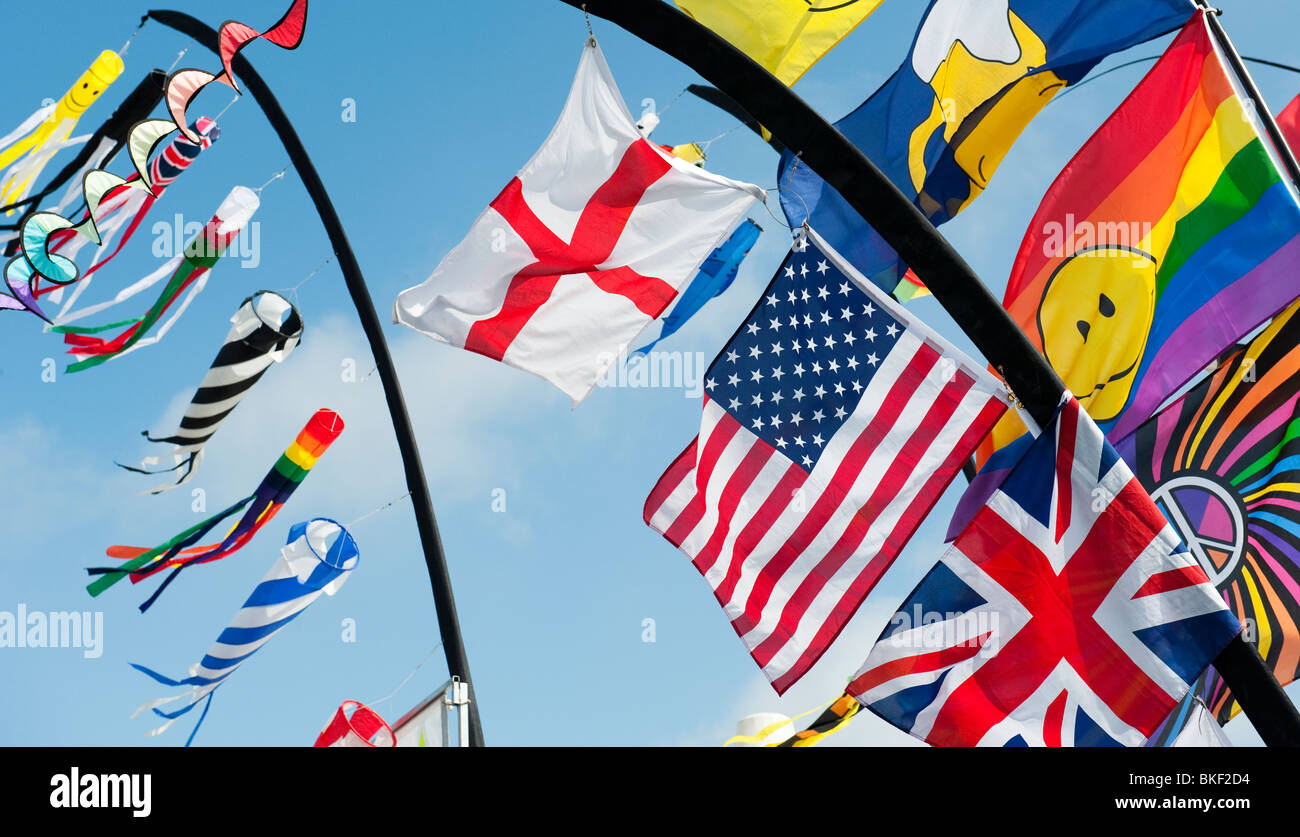 Leuchtend bunte Fahnen einschließlich der Union Jack, American Flag und George Cross im Wind knattern. Großbritannien Stockfoto