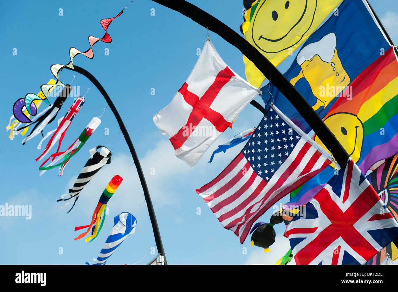 Leuchtend bunte Fahnen einschließlich der Union Jack, American Flag und George Cross im Wind knattern. Großbritannien Stockfoto