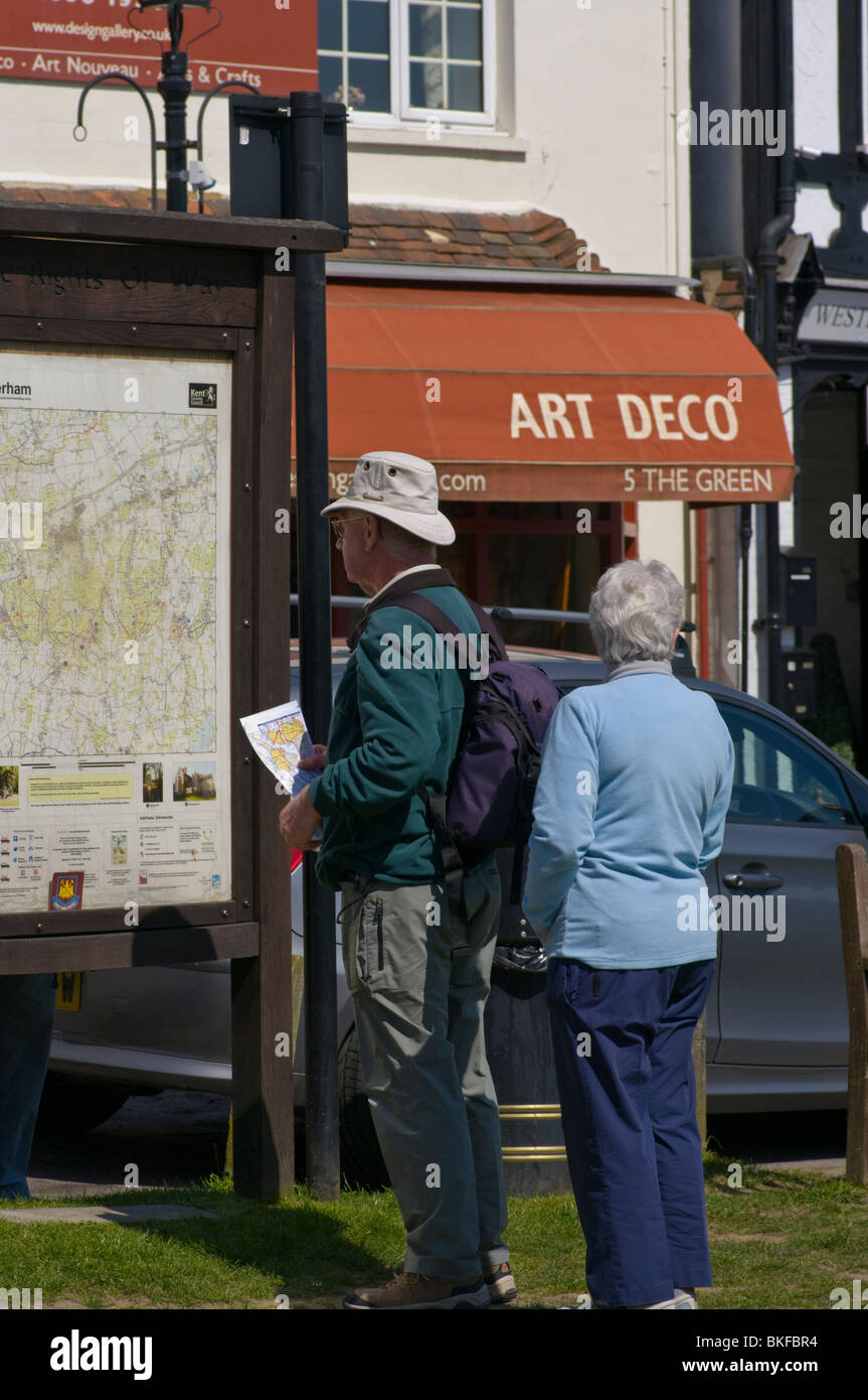 Ein älteres Ehepaar Beratung einen Lageplan auf Westerham Village Green Kent England Stockfoto
