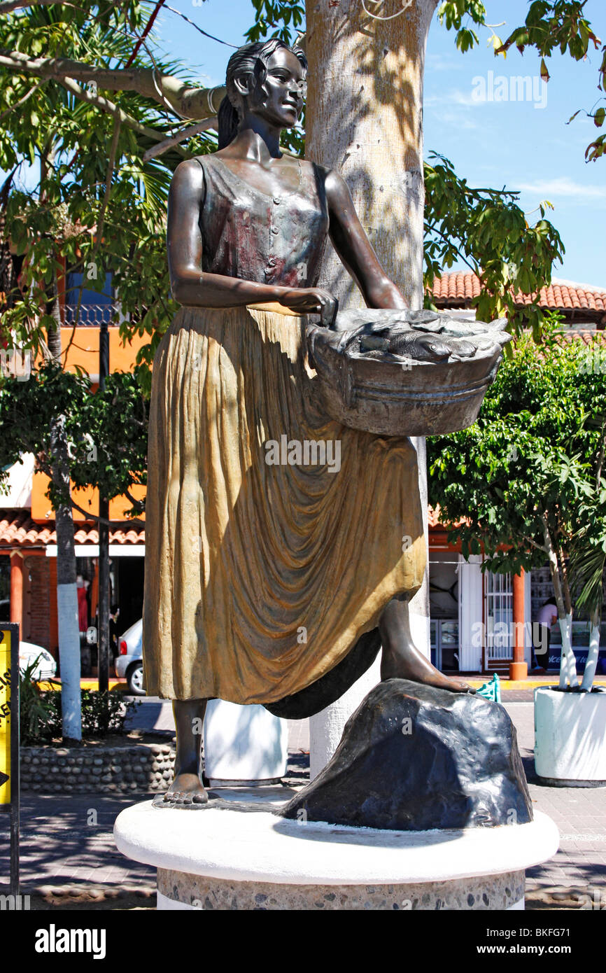 Statue einer Frau mit einem Korb voller Fische an der Küste von Zihuatanejo, Mexiko. Stockfoto