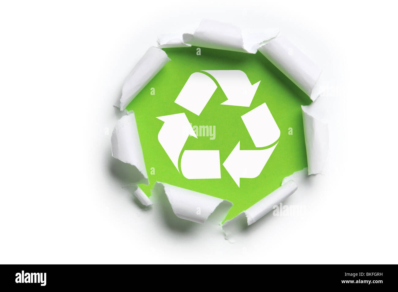 zerrissenes weißes Papier mit Recycling-Logo vor einem grünen Hintergrund Stockfoto