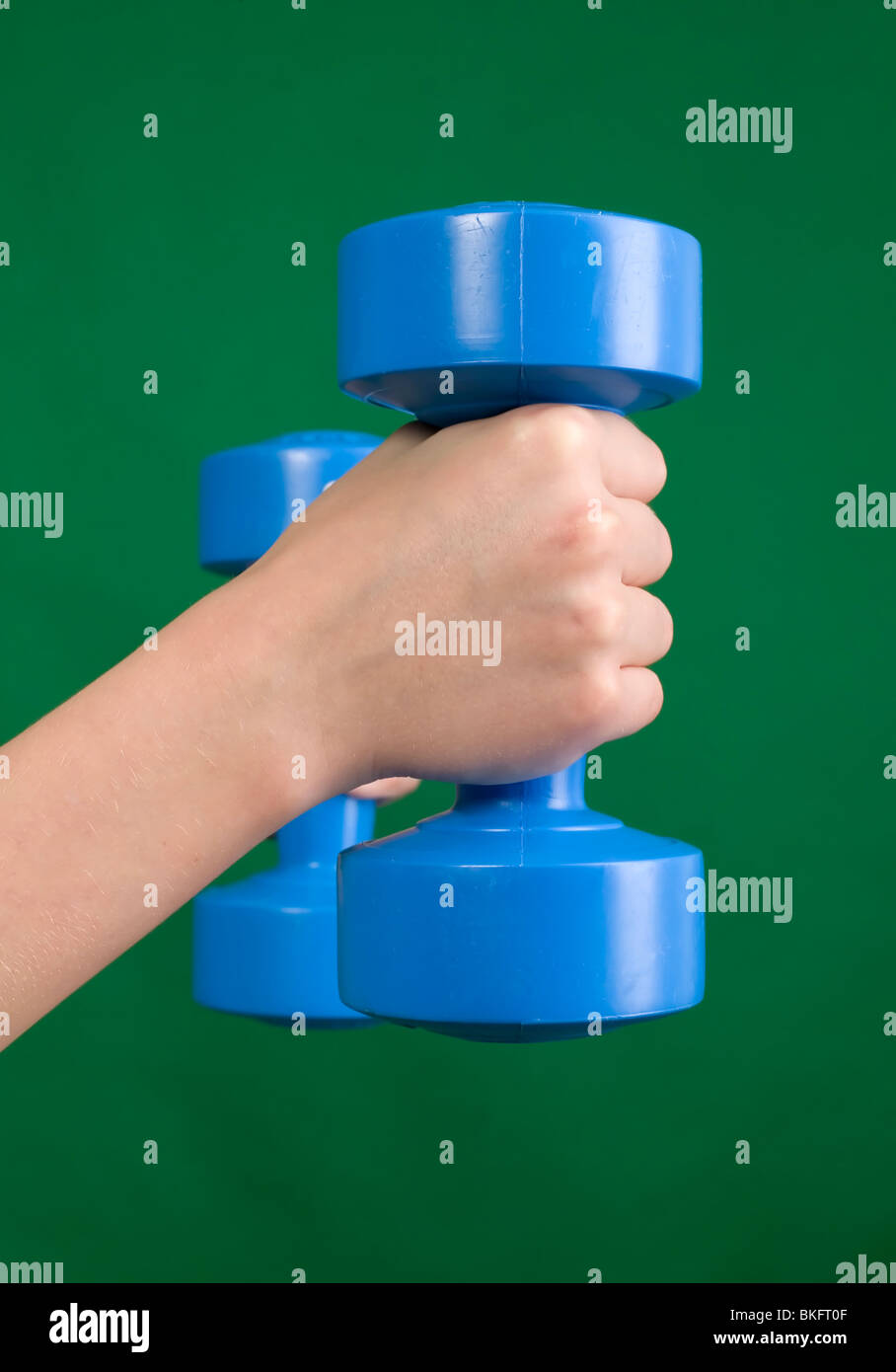Menschliche Hand hält blau Hantel, grüner Hintergrund Stockfoto