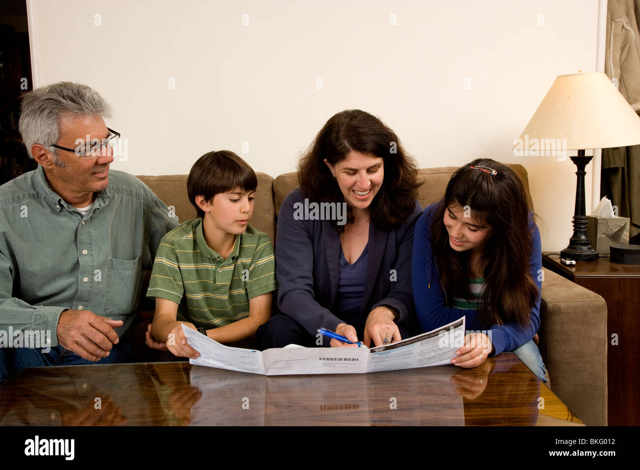 Weiße vierköpfige Familie lächelnd, während sie heraus die Volkszählung, USA 2010., junge 11 Mädchen 13 füllen. Stockfoto
