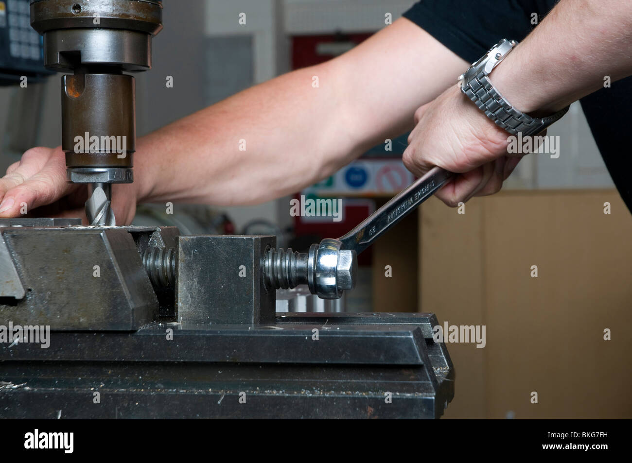 Spannteil auf dem Platz in einer Fräsmaschine mit einem Maschinen-Schraubstock, mit einem Maulschlüssel festziehen Feinmechanik. Stockfoto
