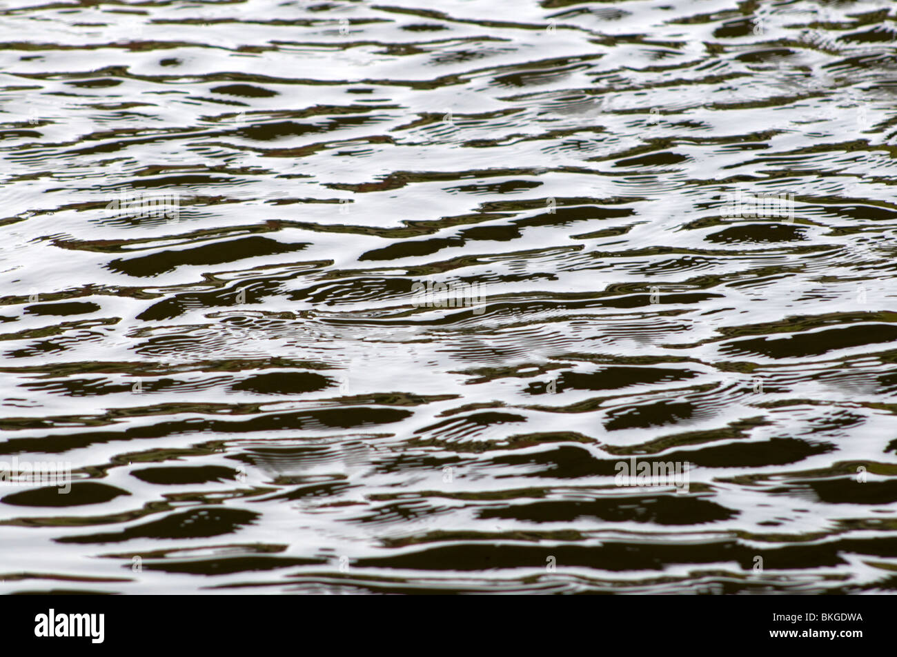 Wellen im Wasser unter einer Brücke. Stockfoto