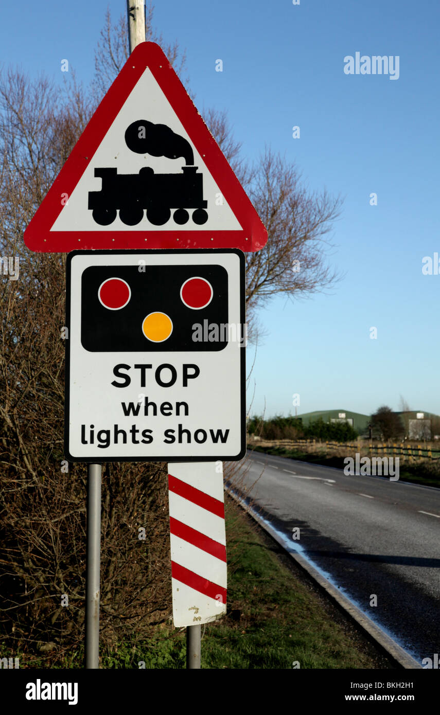 Am Straßenrand Schild Warnung vor einer nahenden Bahnübergang. Stockfoto
