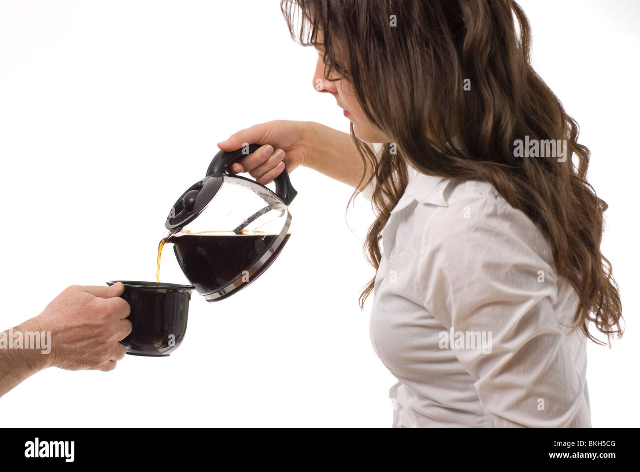 Junge Frau gießt Kaffee Stockfoto