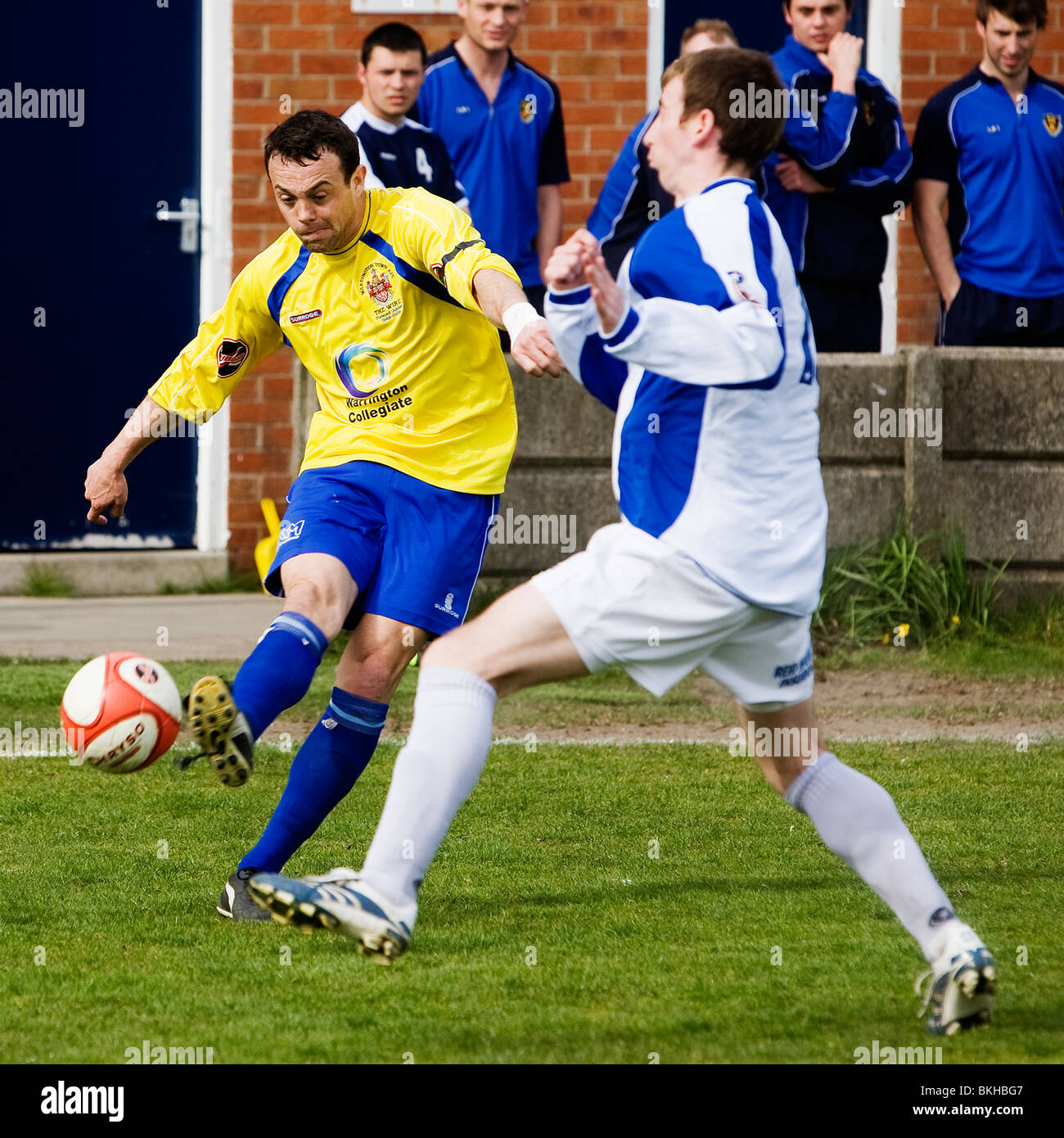 Warrington Stadt Spieler kickt den Ball auf das Ziel mit anderen beobachten während einer Unibond Teilung eine Nord-Fußballspiel Stockfoto