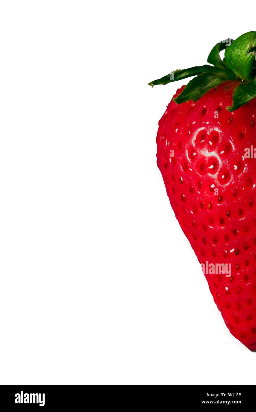 Schneiden Sie aus. Eine halbe Erdbeere auf der rechten Seite des Bildes auf weißem Hintergrund. Stockfoto
