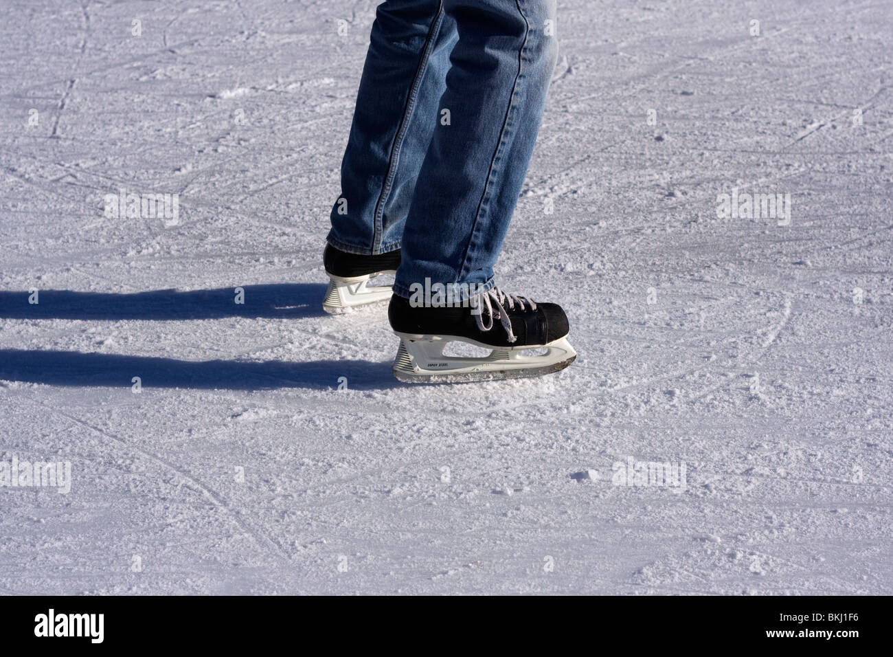 Beine der Schlittschuhläufer auf der Eisbahn. Stockfoto
