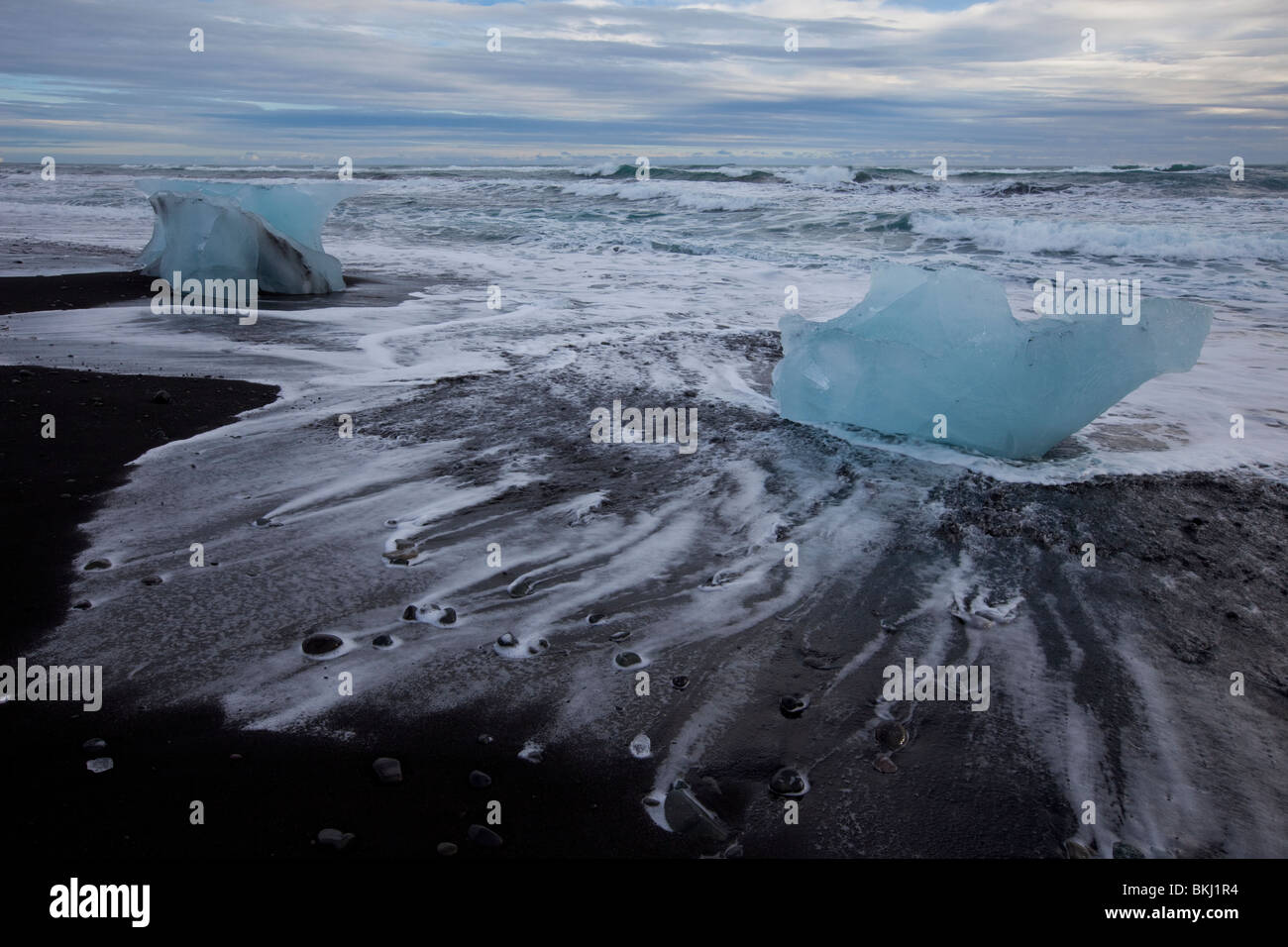 Eisberge am Strand Jökulsarlon sind durch das Wasser im Winter in Island umspült. Stockfoto