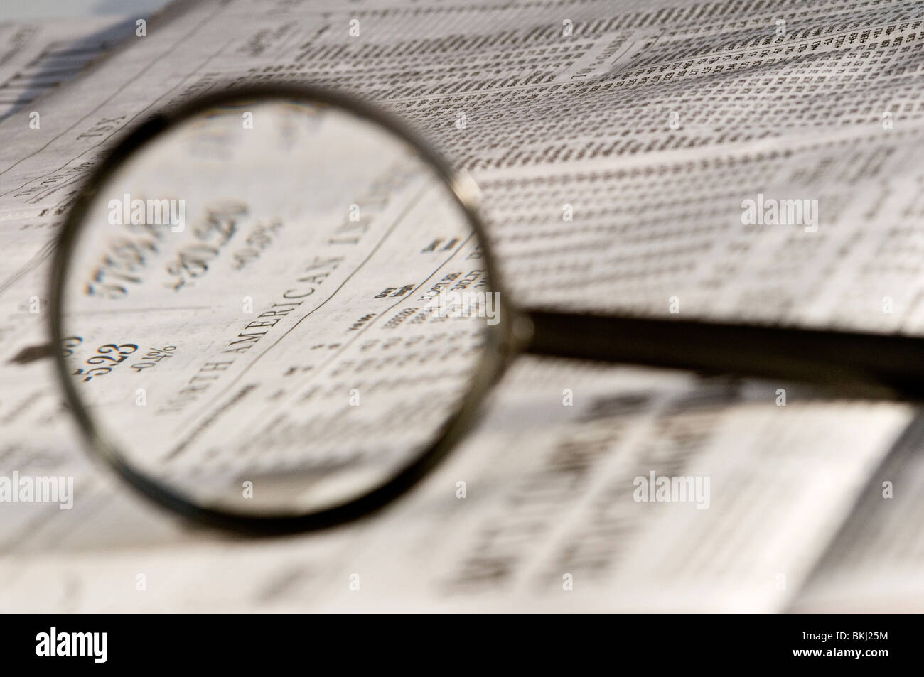 Lupe Hervorhebung Aktienkurse im Wirtschaftsteil der Zeitung. Stockfoto