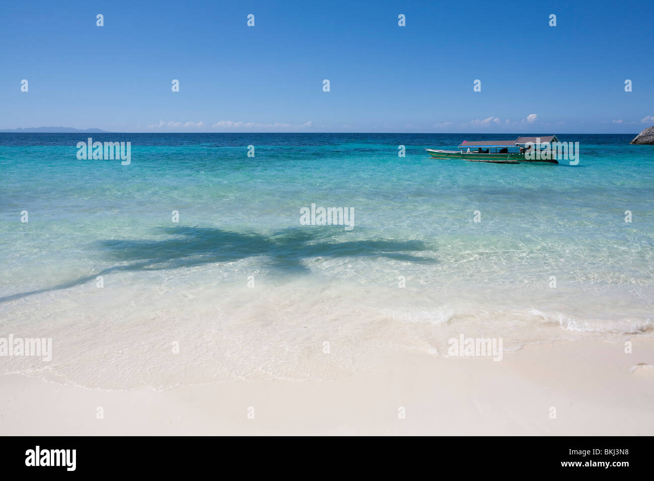 Einer sonnigen tropischen Insel mit Strand und blauer Himmel. Stockfoto