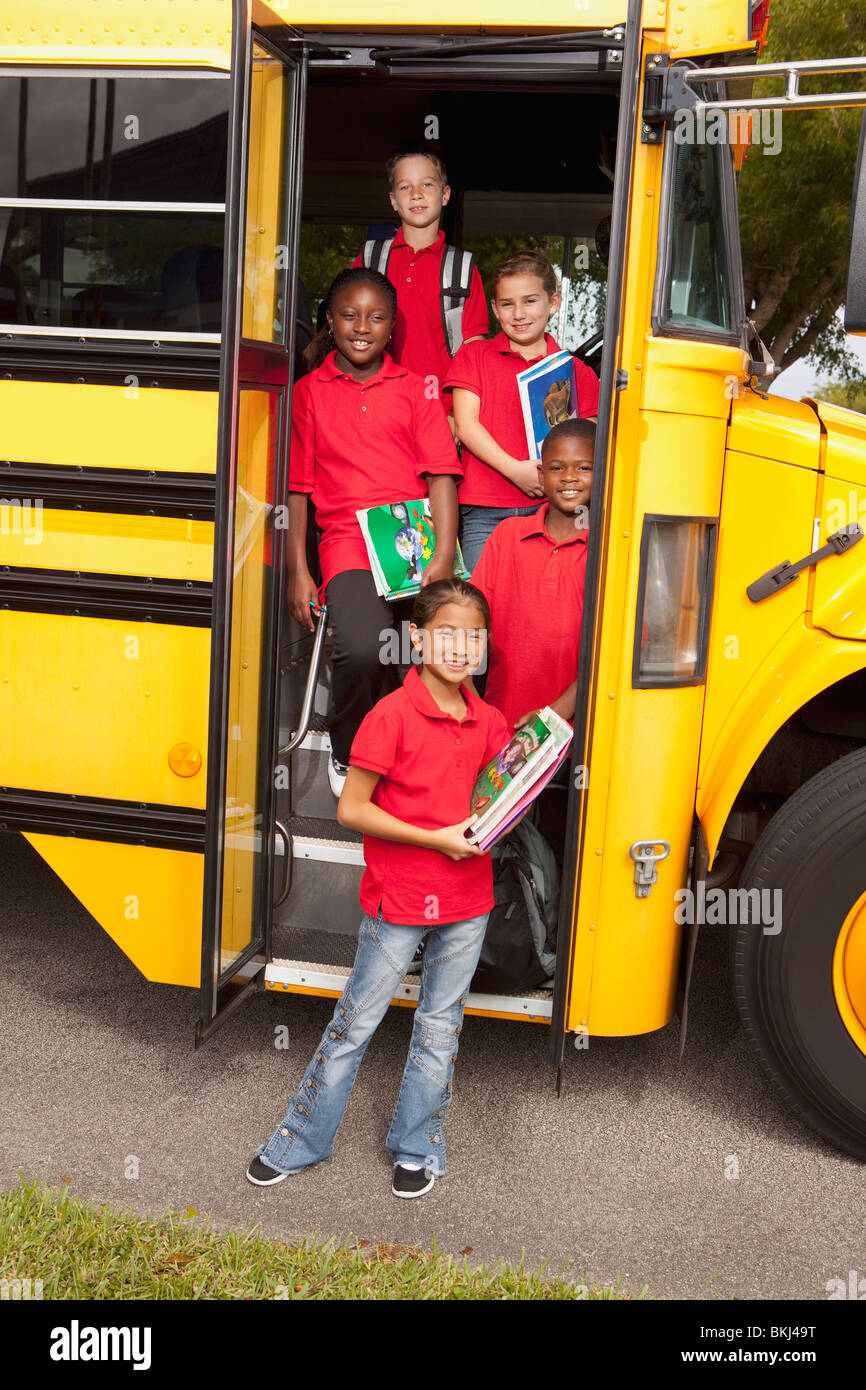 Studenten stehen vor der Tür eines Schulbusses Stockfoto