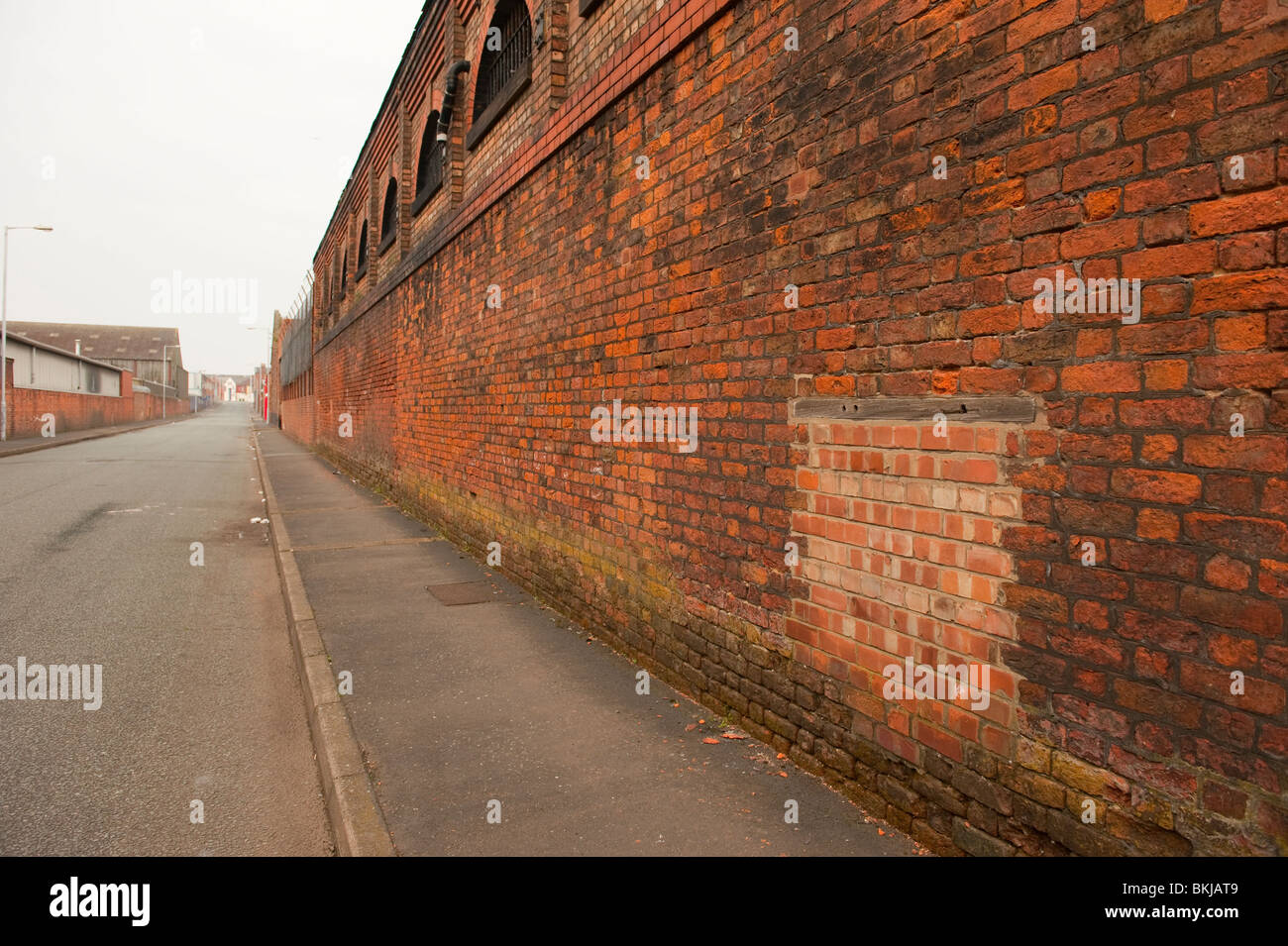 Lange leere Ziegel Wand Ausbleichung Fluchtpunkt in Ferne Stockfoto