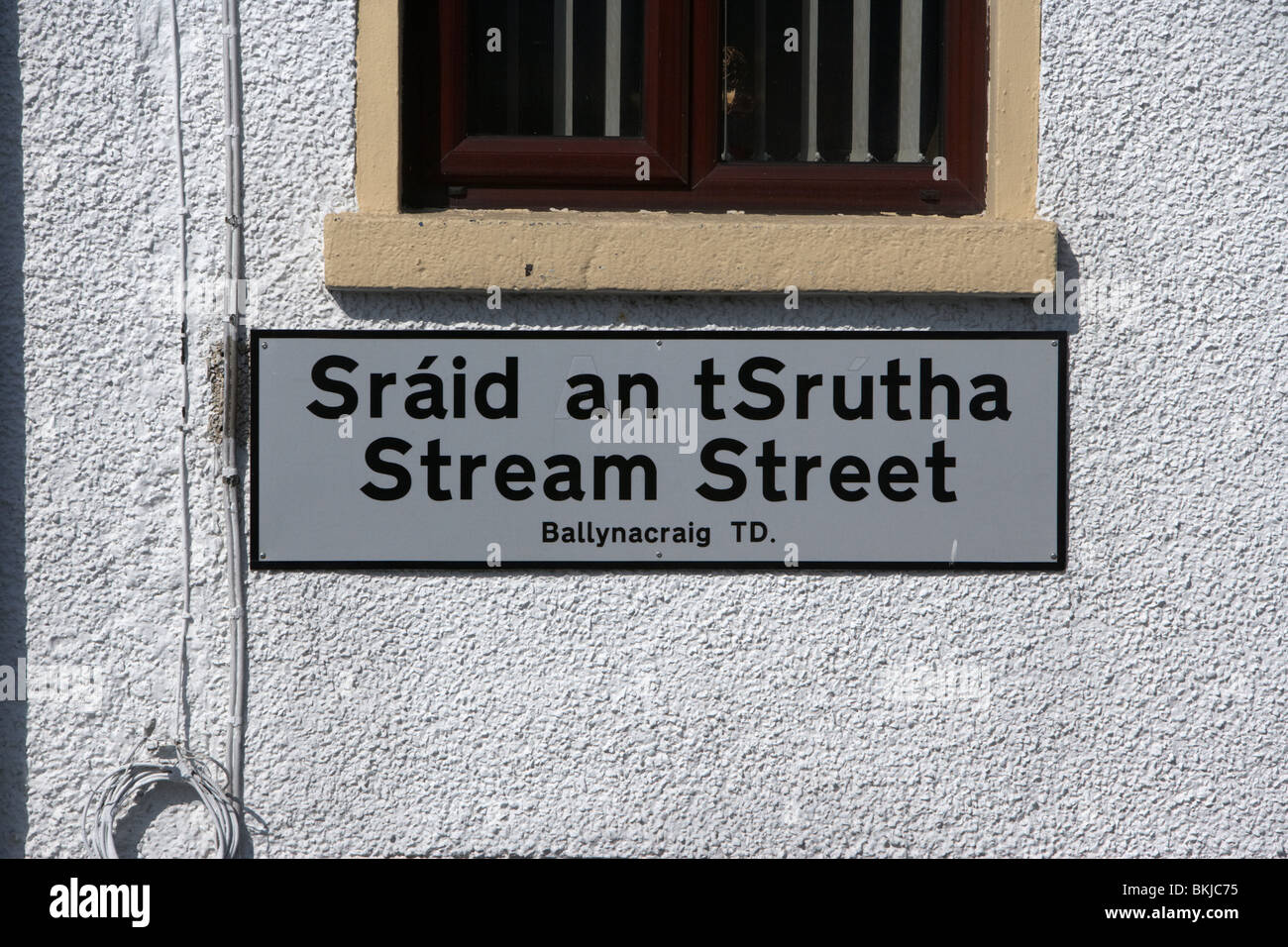 korrigierte irische Schreibweise auf ein zweisprachiges Straßenschild im gälischen und englischen Stream Straße Newry County down Nordirland Vereinigtes Königreich Stockfoto
