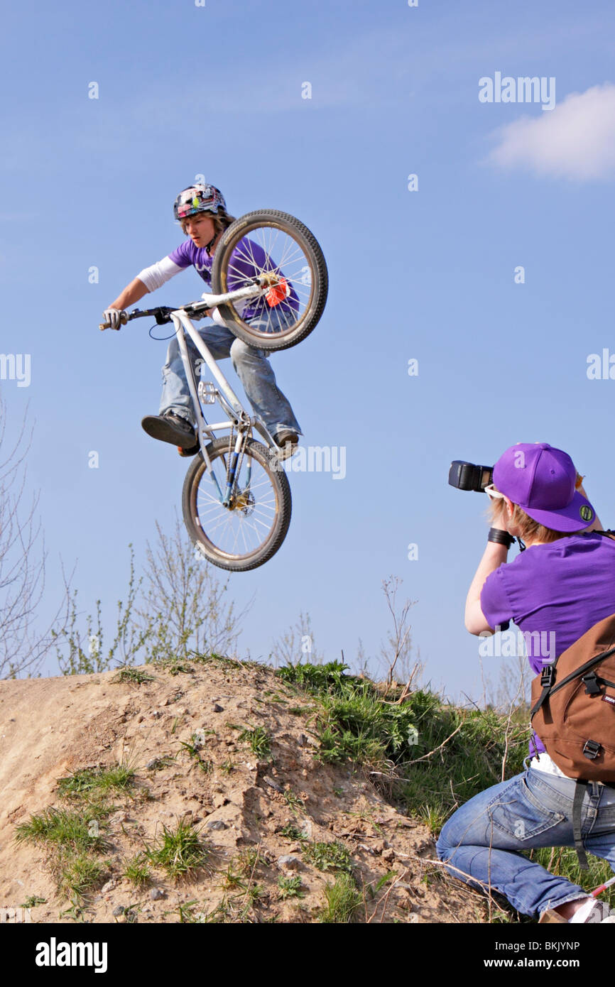 Teenager-Jungen springen mit seinem Motorrad seines Freundes Foto von ihm nehmen Stockfoto