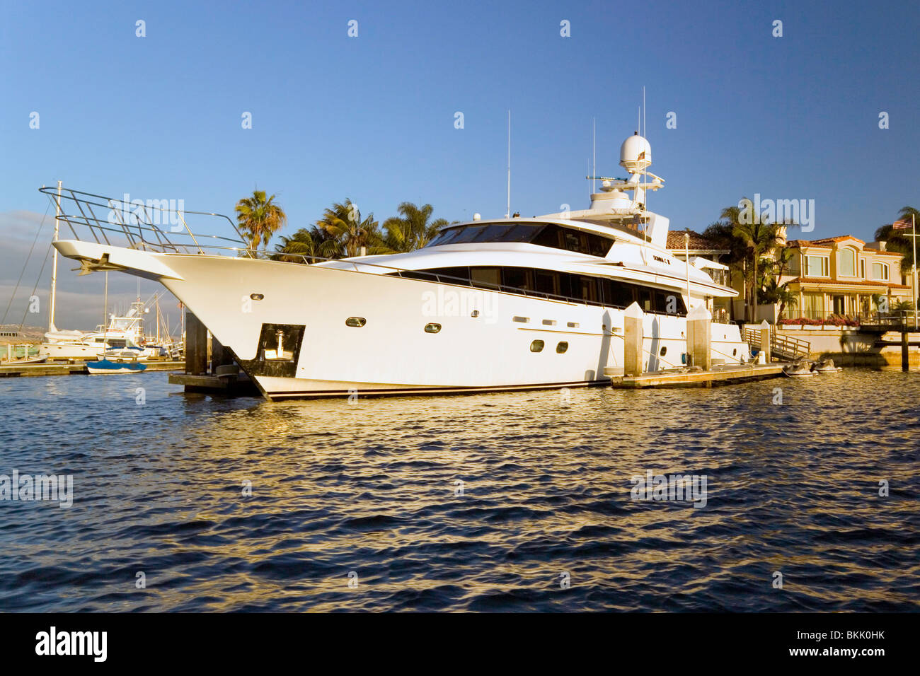 Große luxuriöse Yachten und ausgefallene Multimillionen-Dollar-Häuser sind jeden Tag Sehenswürdigkeiten im Hafen von Newport in Newport Beach in Süd-Kalifornien, USA. Stockfoto