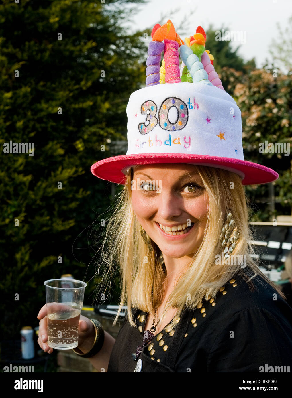Eine Frau trägt einen albernen Hut ihren 30. Geburtstag feiert. Stockfoto