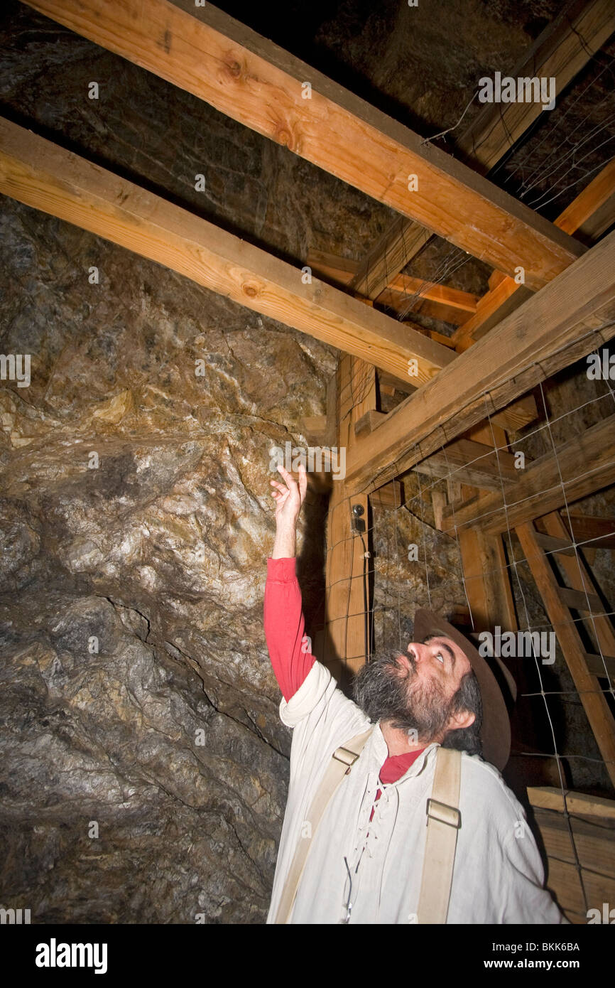 Mann zeigt zum Beispiel der Mine verschalen verwendet, um Tunnel in alten California Gold Mine zu stabilisieren Stockfoto