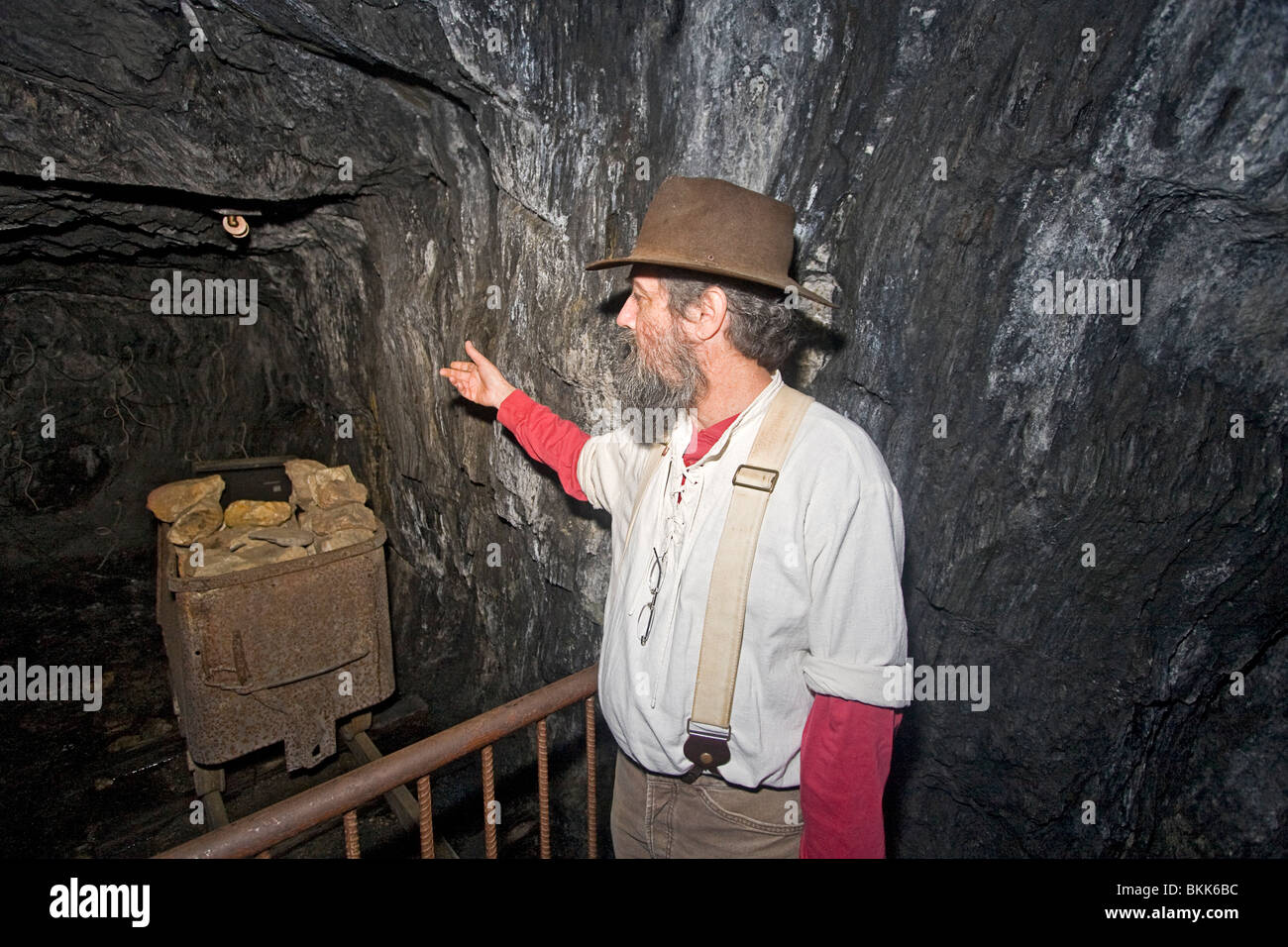 Man verweist auf Erz-Wagen im alten California Gold mine Stockfoto